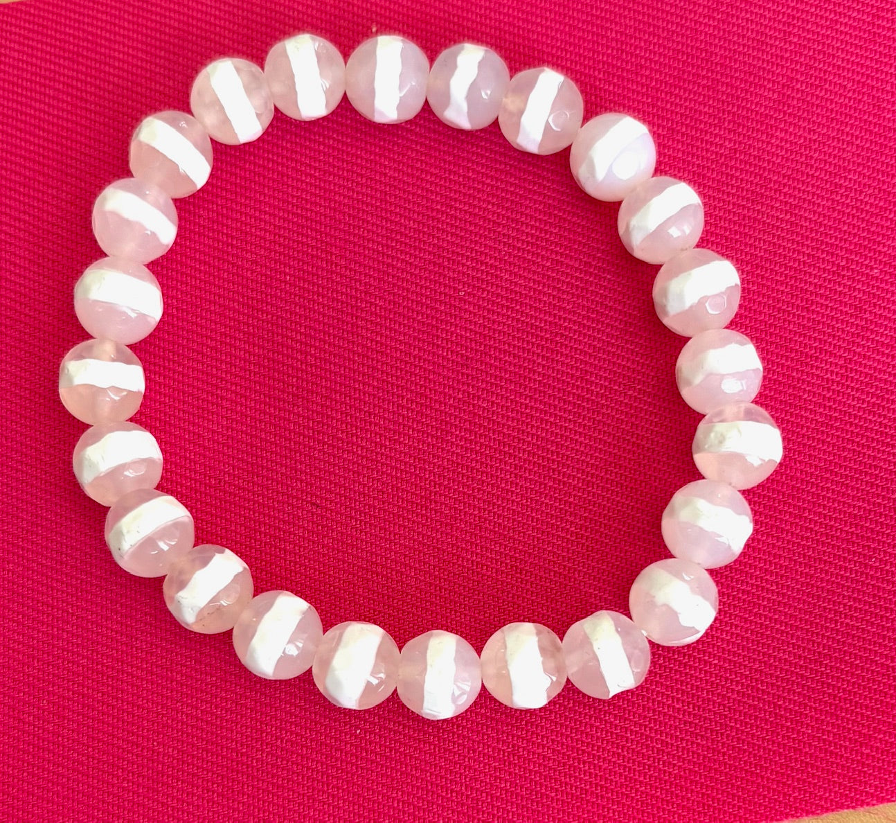 White beaded bracelet on a red background