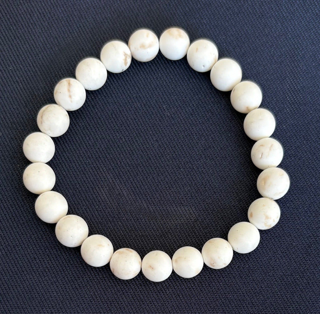 White turquoise bracelet on a dark blue fabric background