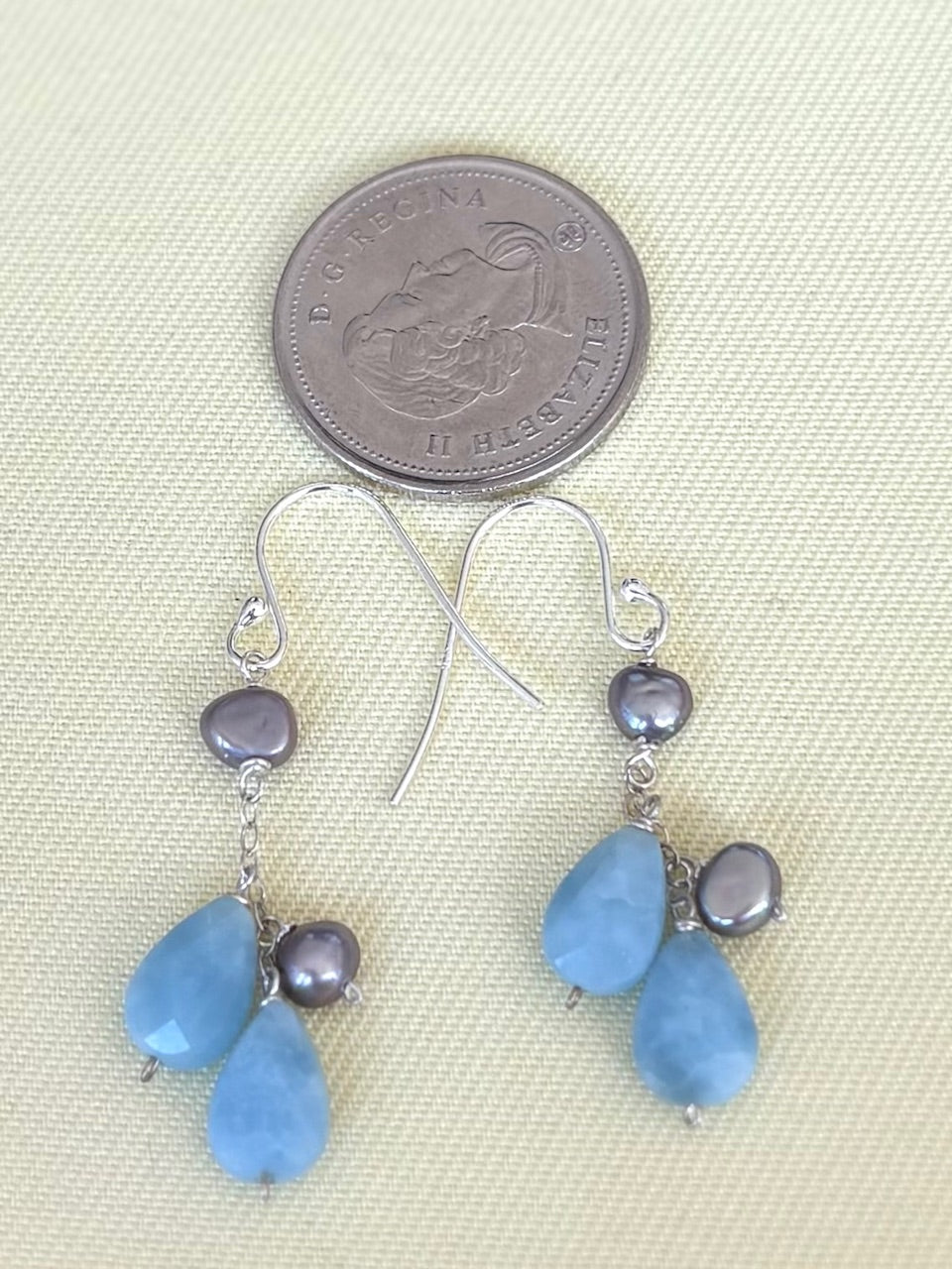 Jolie Esprit pair of blue amazonite teardrop earrings with silver hooks on a light green background.