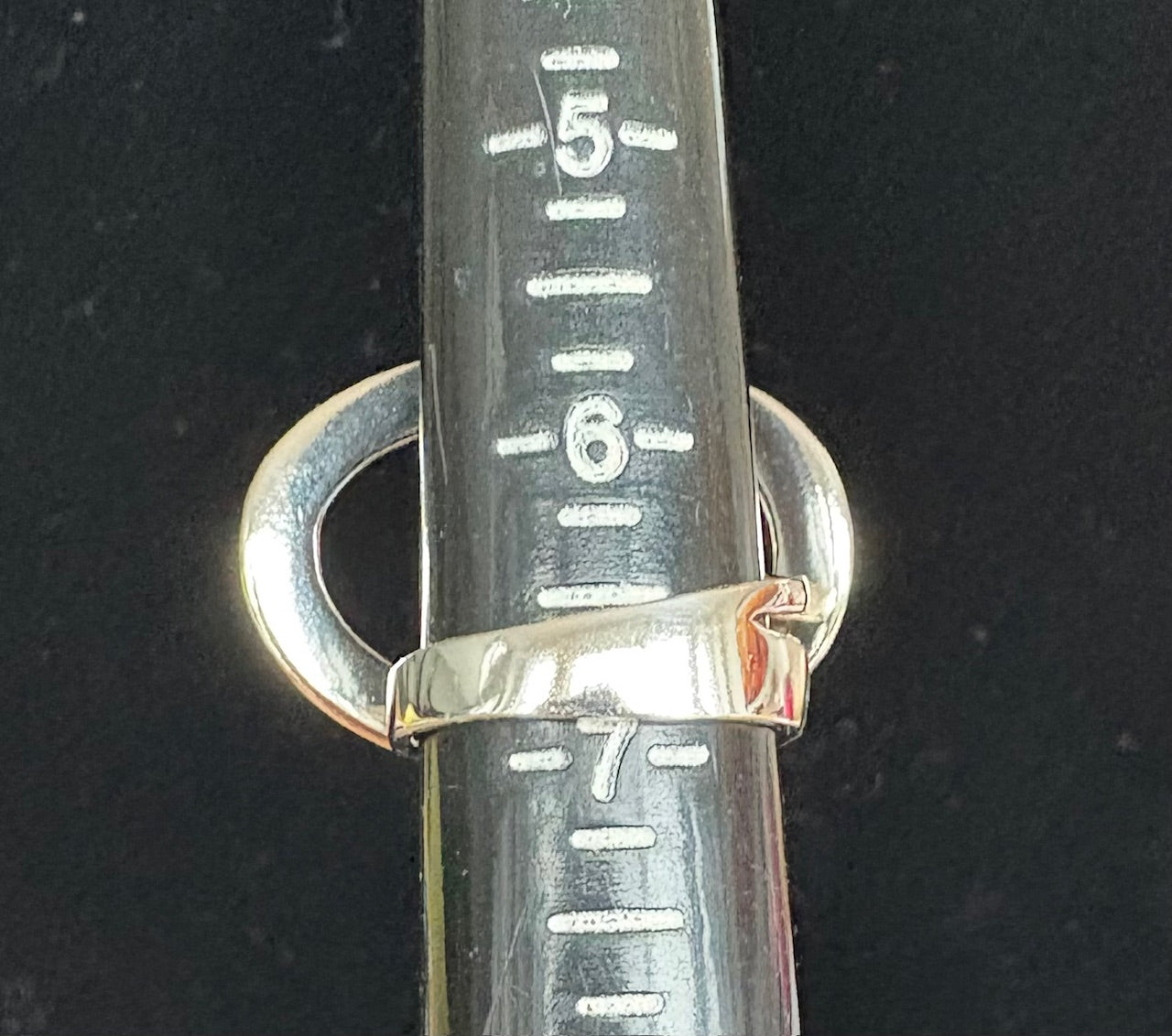 Silver ring on a black background with measurement scale