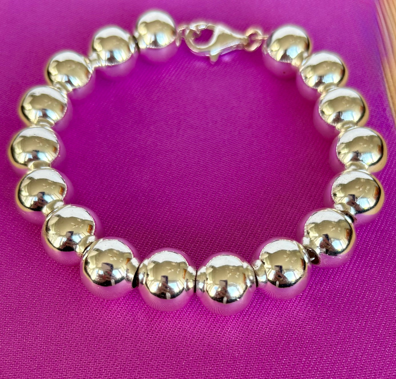 Sterling Silver Ball Bracelet on a pink background by Jolie Esprit