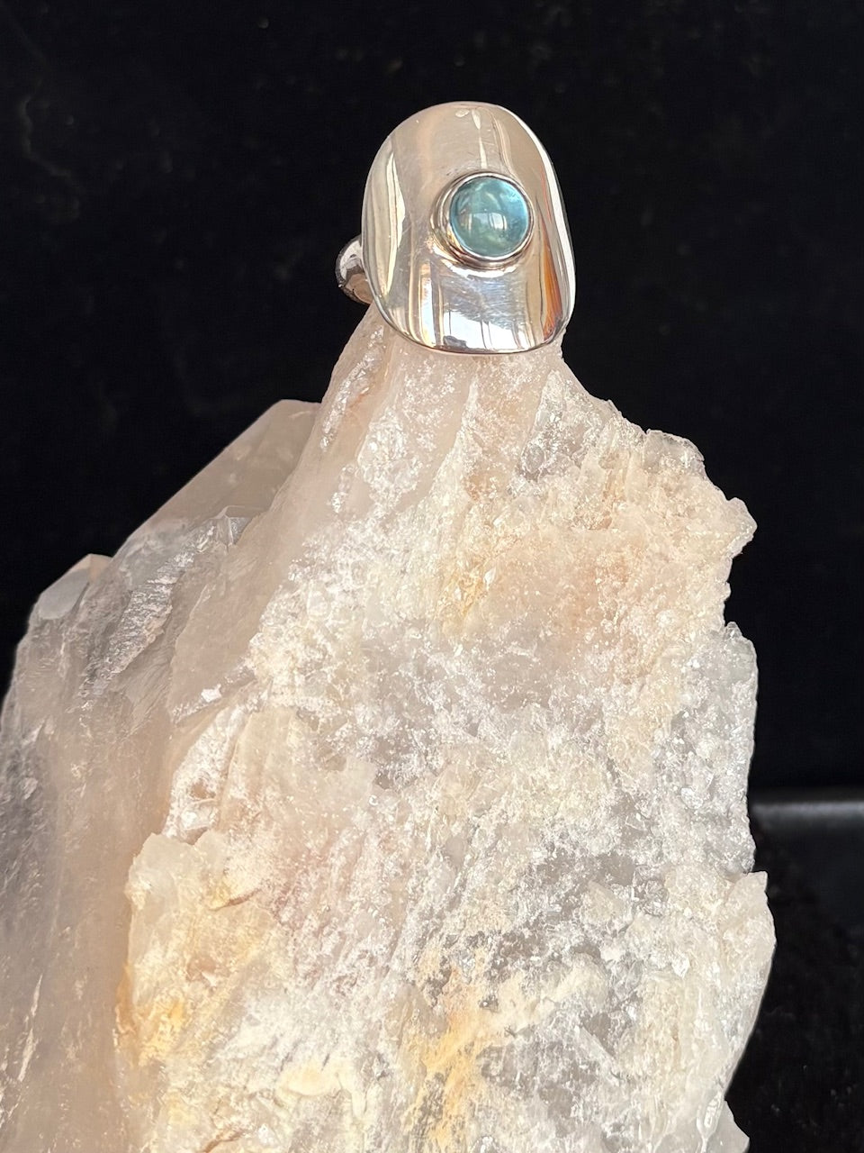 Silver ring with a blue topaz stone on a crystal background