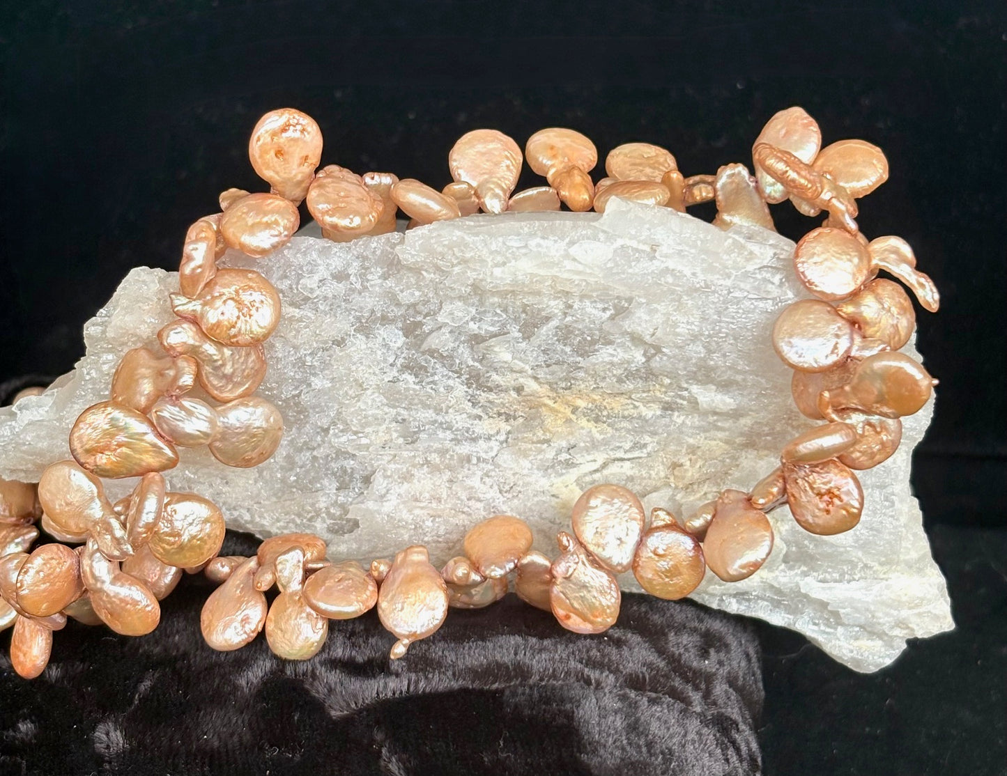Bronze keshi petal pearl necklace on a rock crystal with a dark background