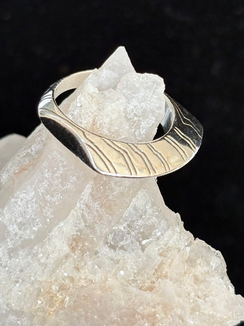 Jolie Esprit Sterling Silver ring with wavy design on a crystal rock against a dark background