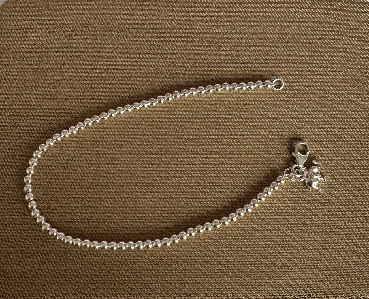 Silver ball bracelet on a brown surface