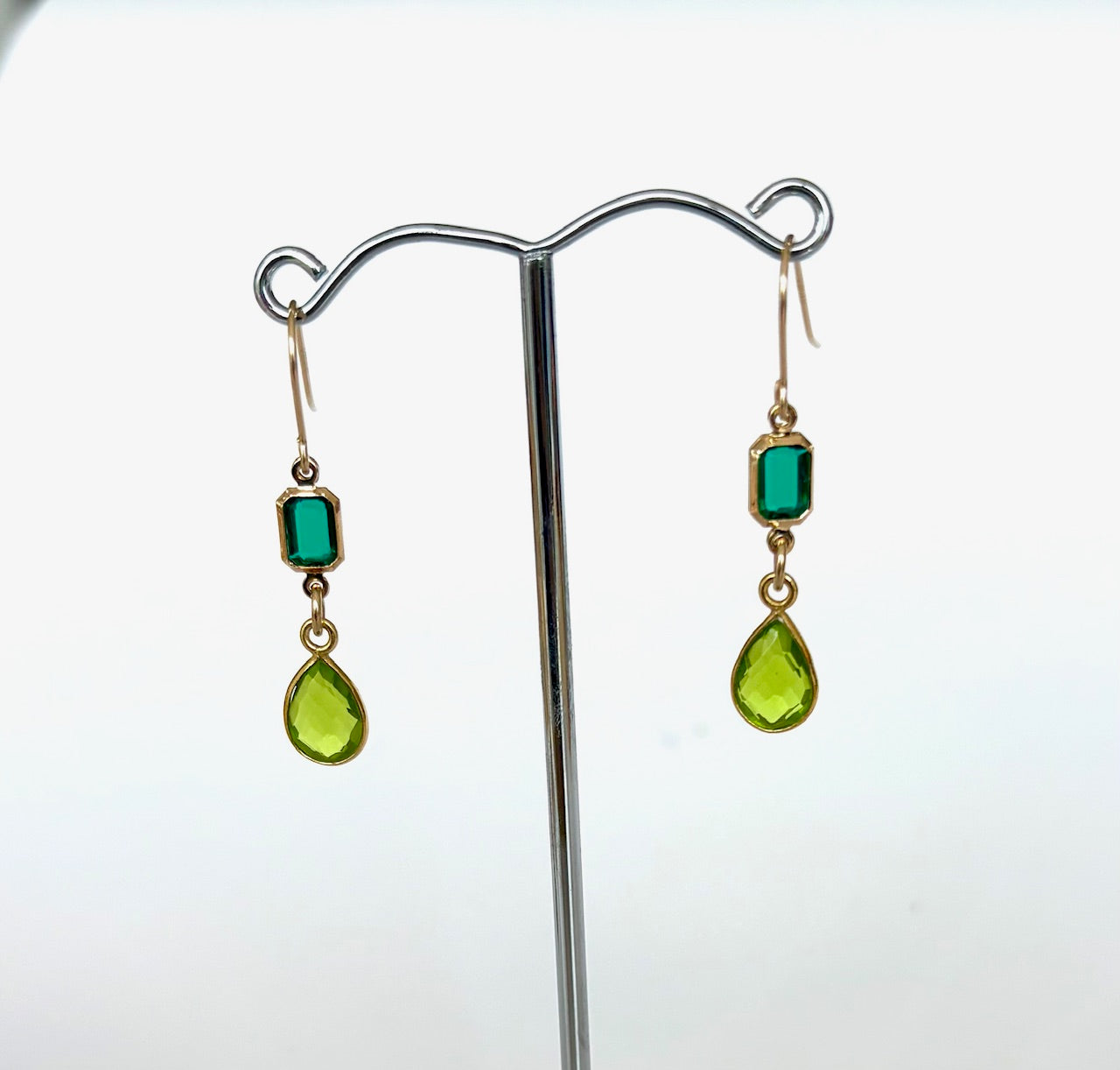 Pair of earrings with green gemstones on a white background