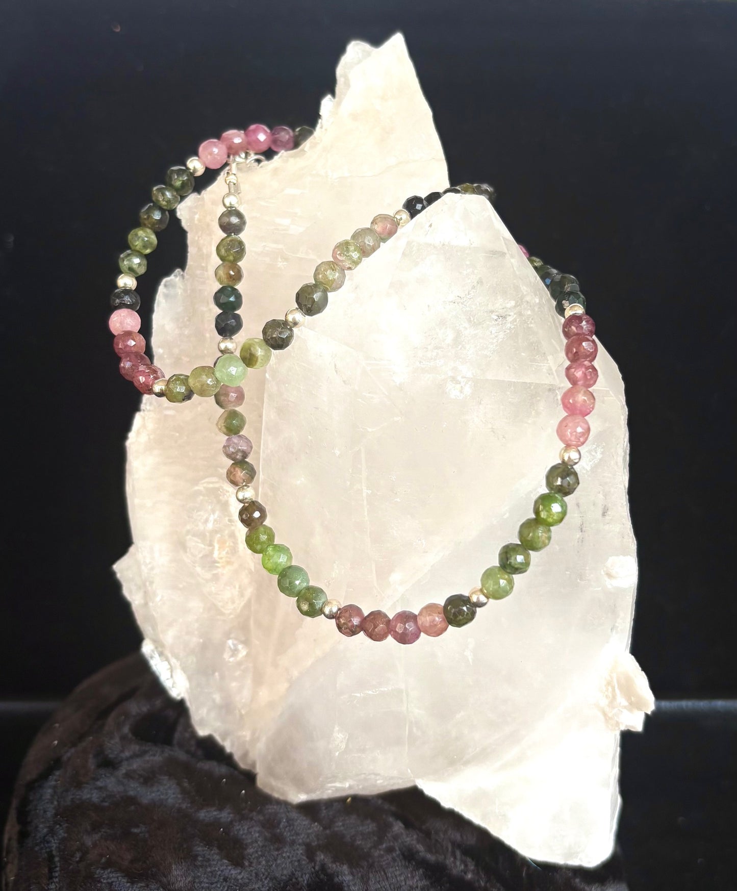 Jolie Esprit multicolored watermelon tourmaline beaded necklace on a white rock with a dark background