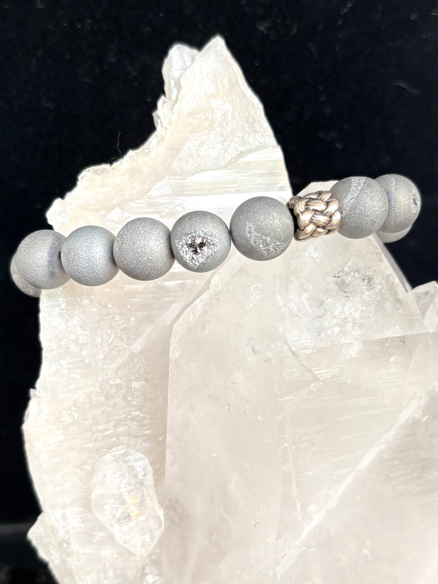 Bracelet with gray druzy stones on a white crystal background