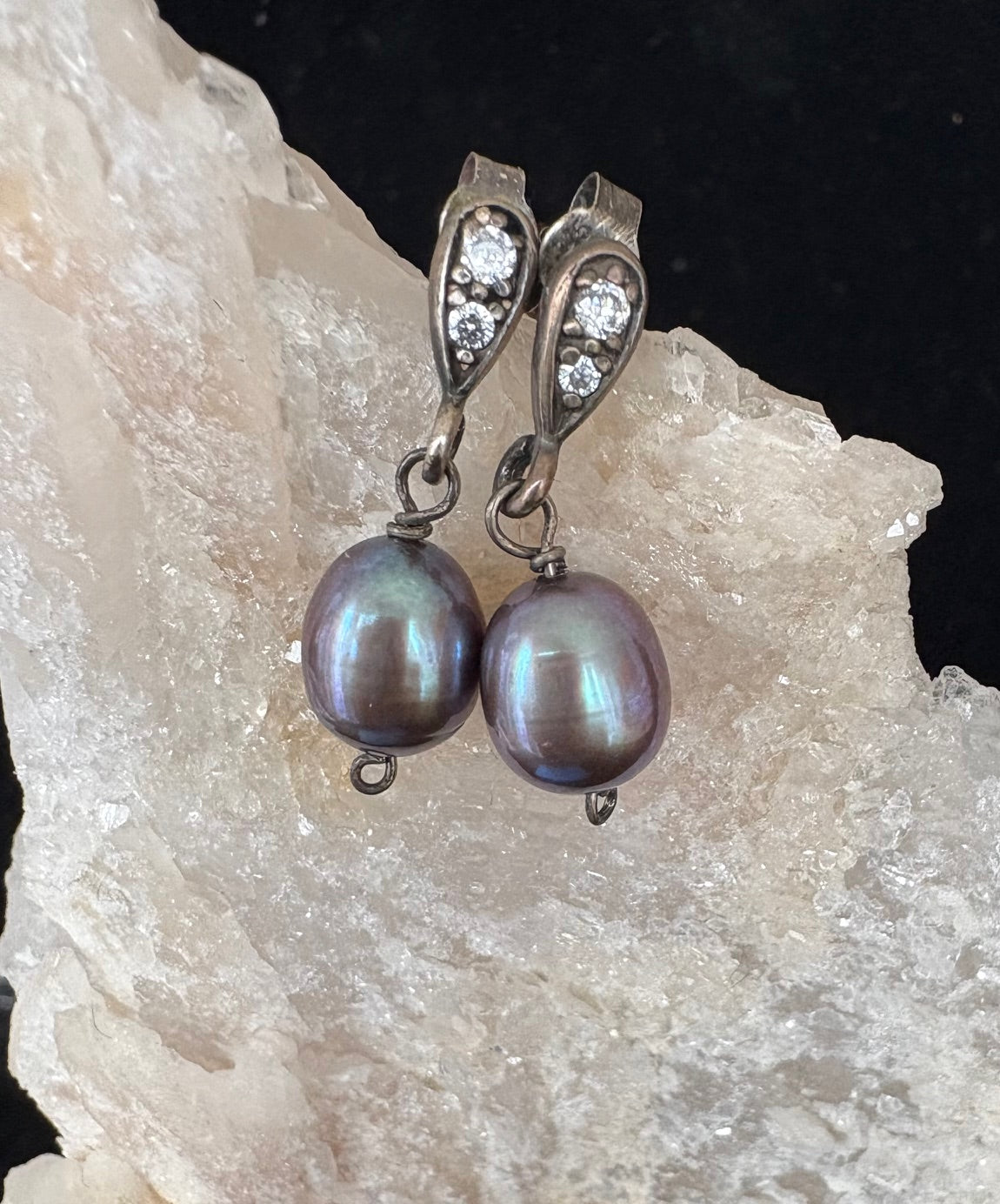 Pearl earrings with pearls and diamond CZ accents on a rock background