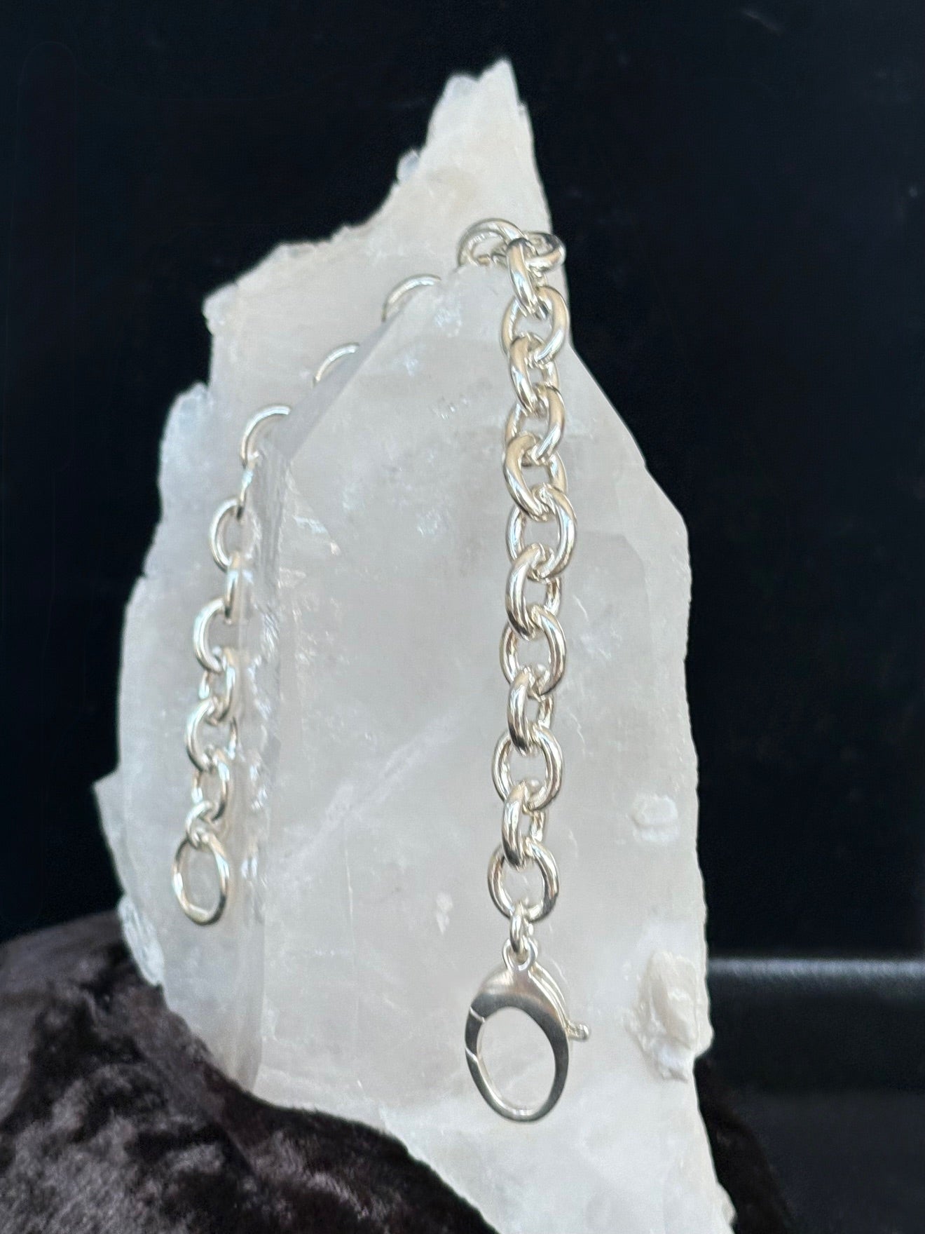Silver chain bracelet on a white stone with a black background
