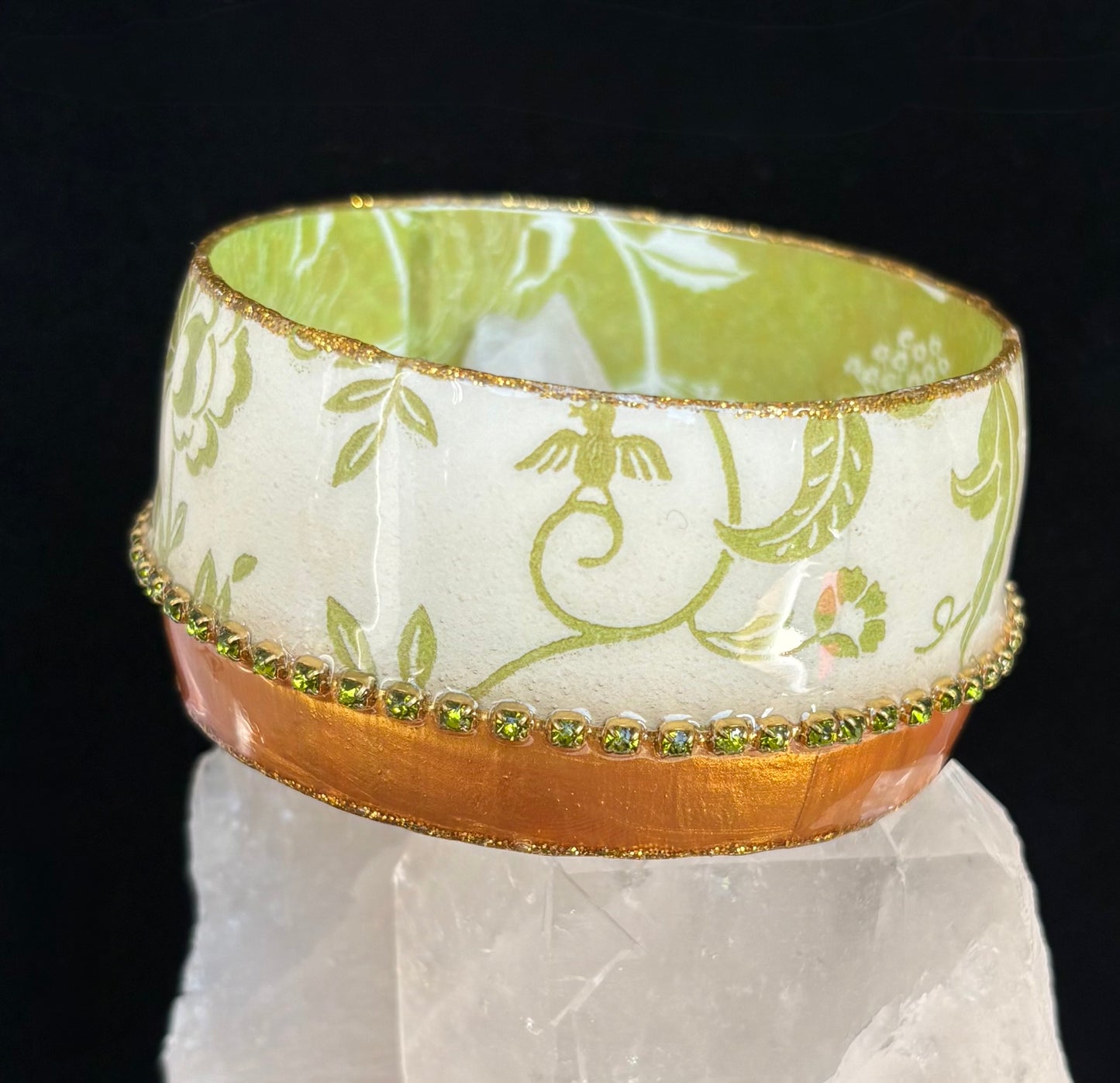 Decorative bangle with floral pattern on a reflective surface