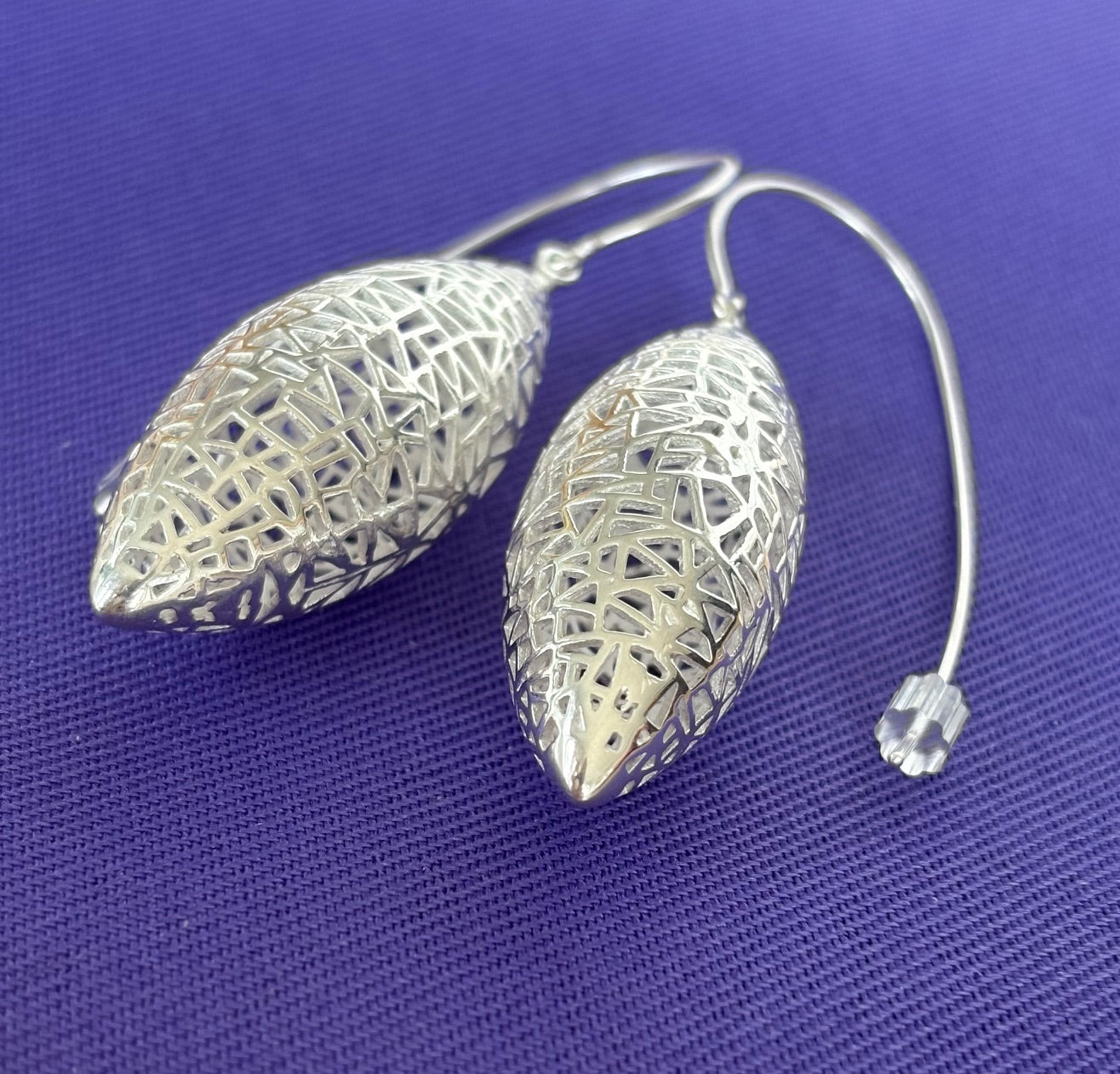 Jolie Esprit sterling silver filigree earrings on a purple fabric background