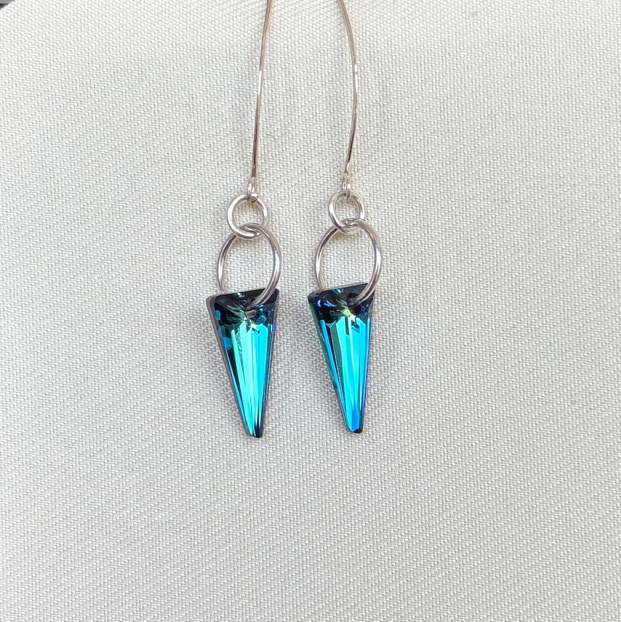 Blue spike earrings on a light gray background