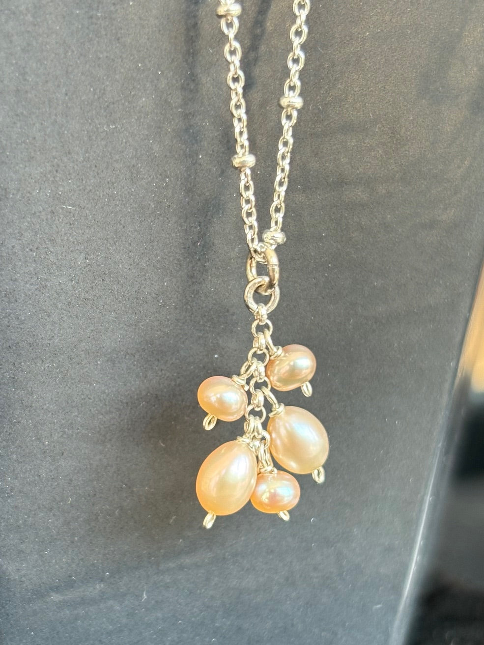 Necklace with peach-colored pearls on a gray background