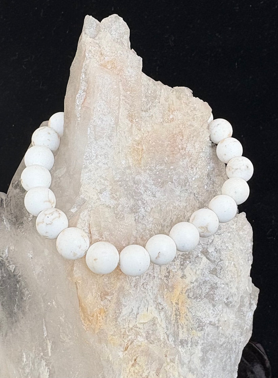 White beaded gemstone bracelet on a crystal rock