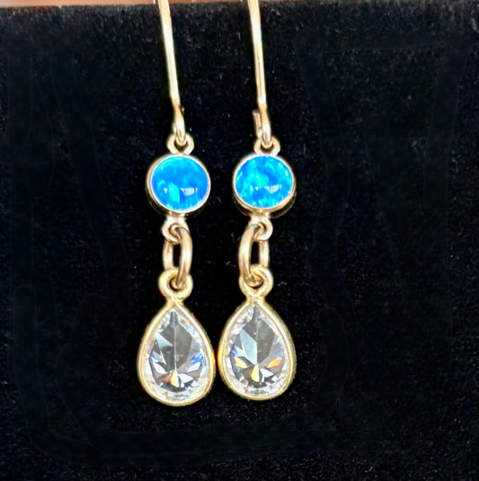 Gold earrings with opal gemstones and teardrop-shaped diamond cz stoneson a black background