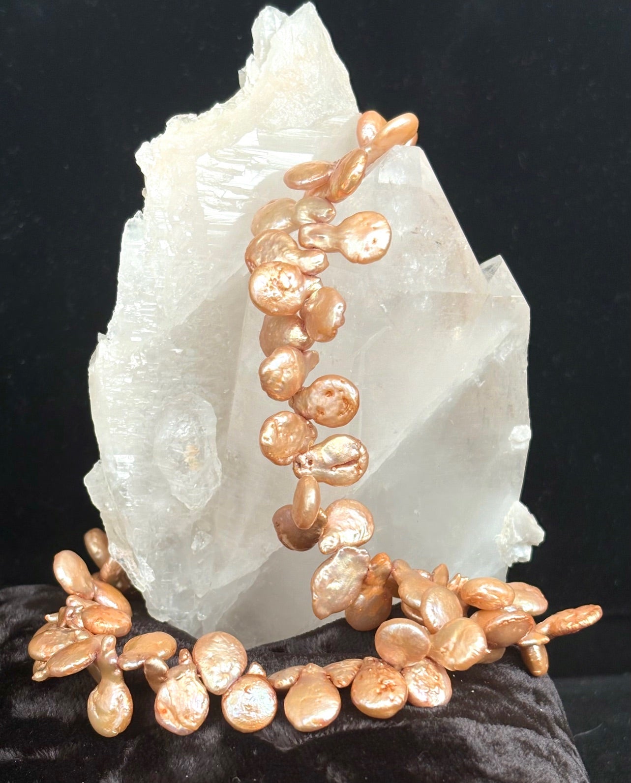 Jolie Esprit bronze-colored keshi petal pearls on a dark background with a large crystal.