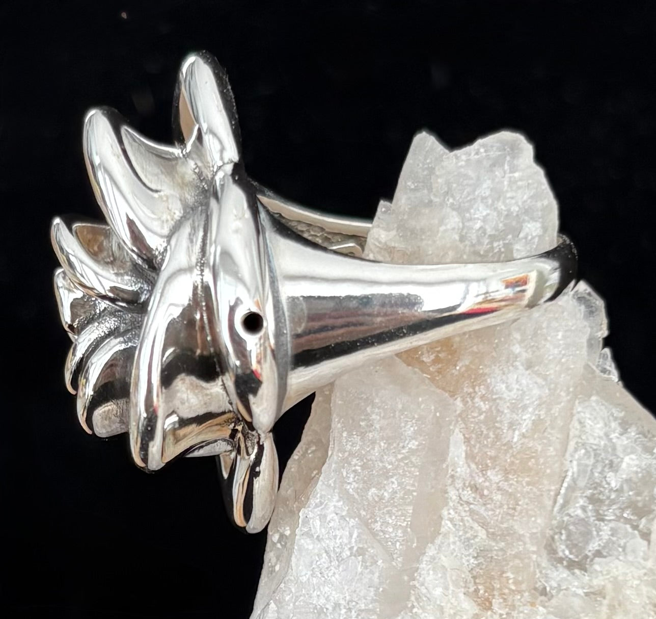 Sterling Silver rose shaped ring side view against a black background