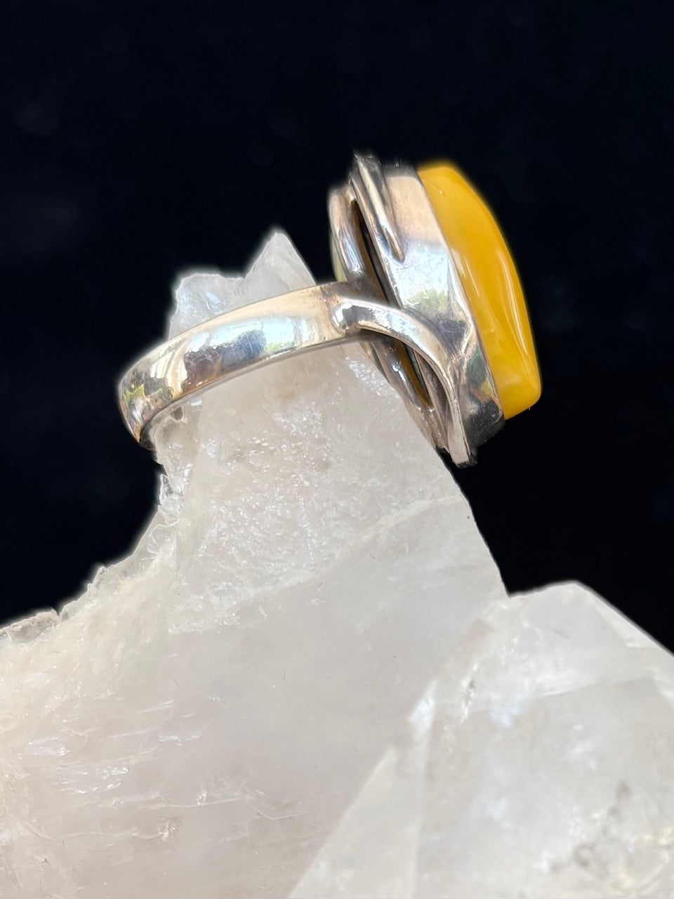 Silver ring with an amber stone on a crystal background