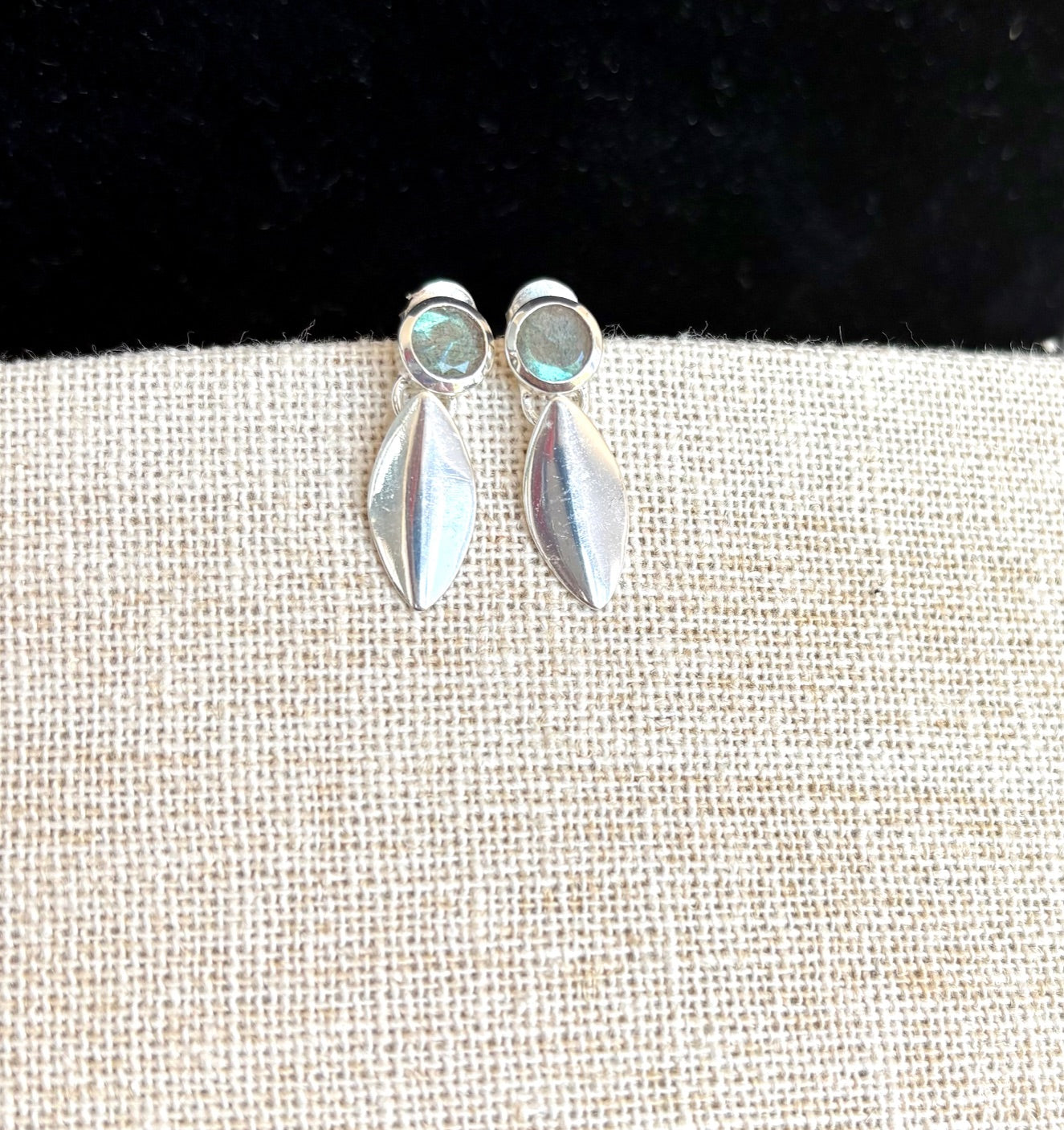 Sterling silver earrings with labradorite gemstones on a textured surface