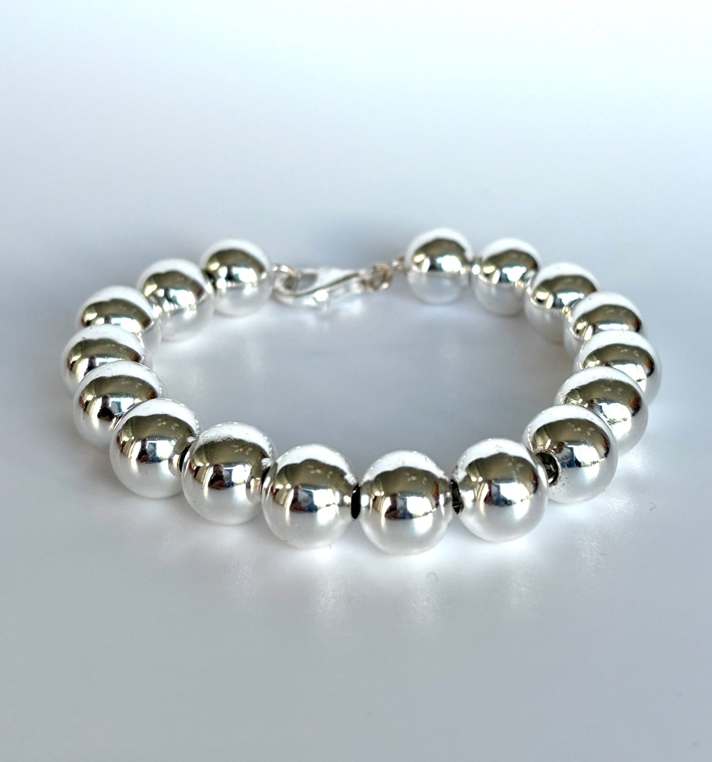 Stelring Silver beaded ball bracelet on a light gray background. Jolie Esprit