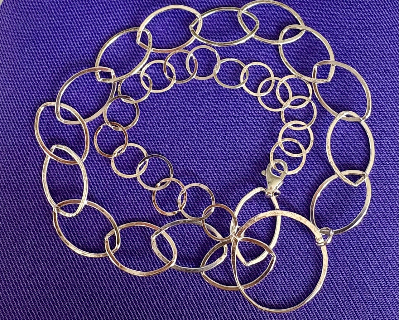 Silver chain necklace on a purple background by Jolie Esprit