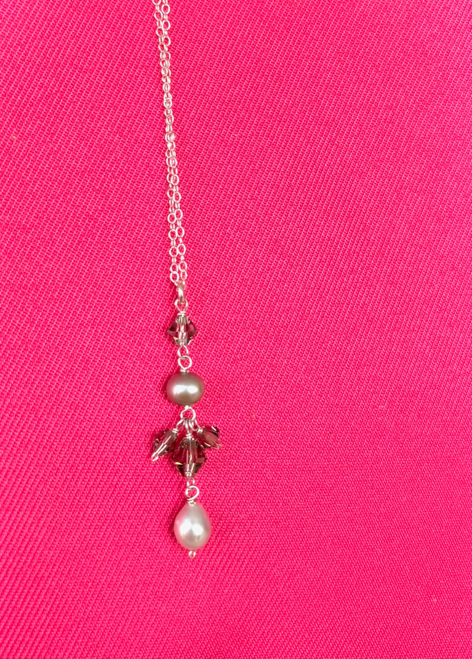 Necklace with pearls and crystals on a pink background