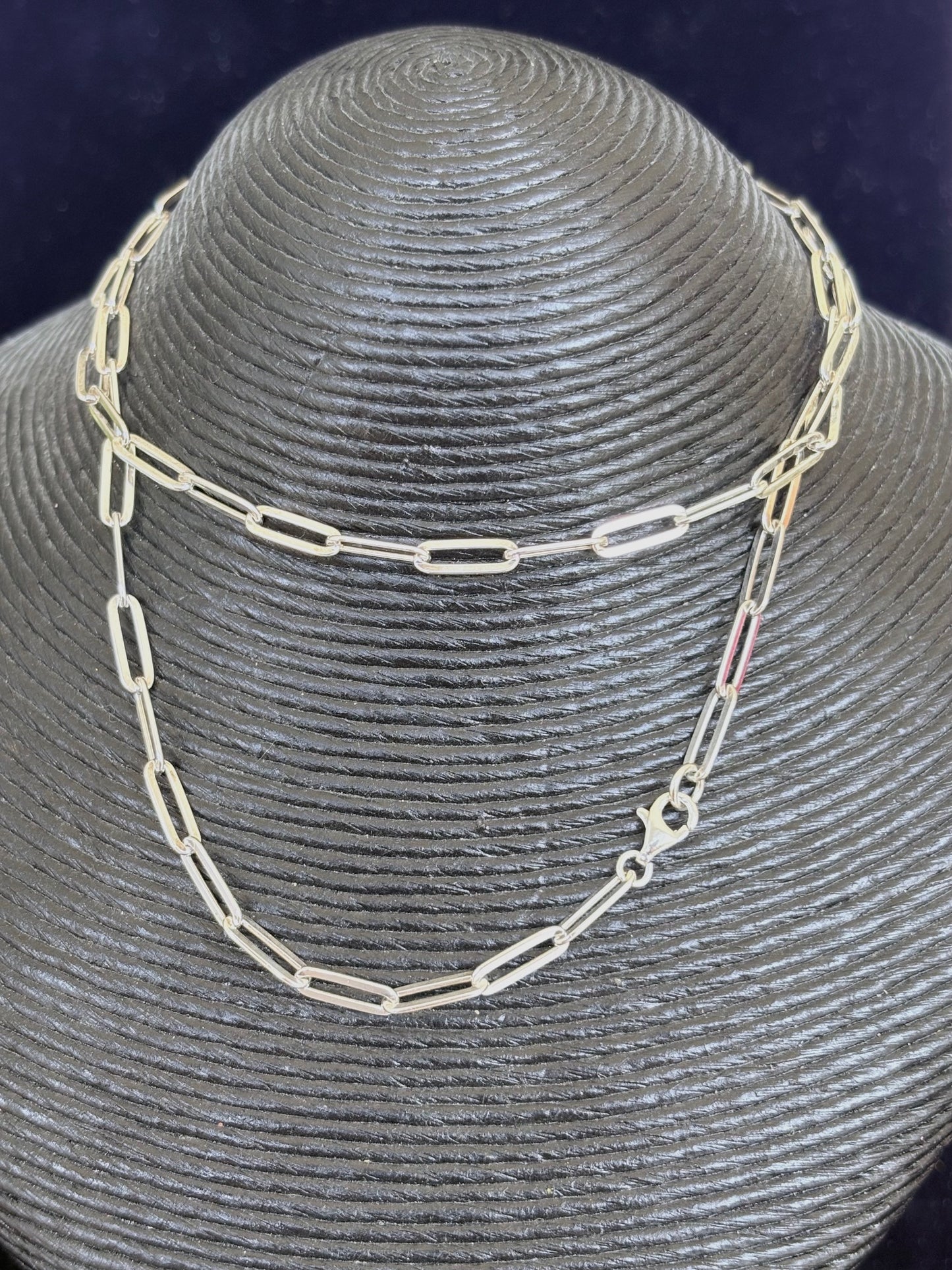 Silver chain necklace on a gray mannequin head