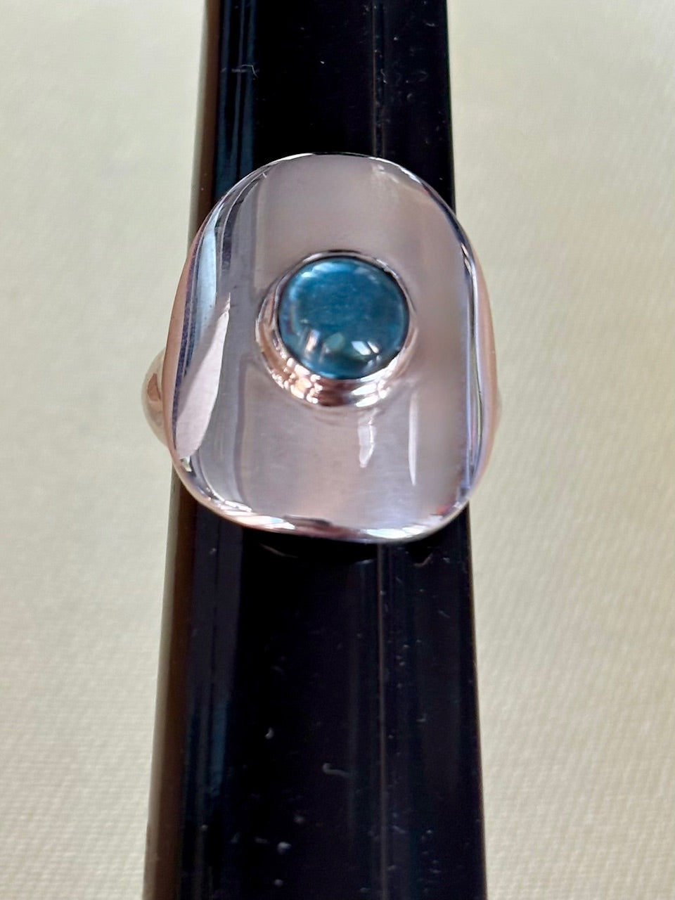 Silver ring with a blue topaz gemstone on a black background