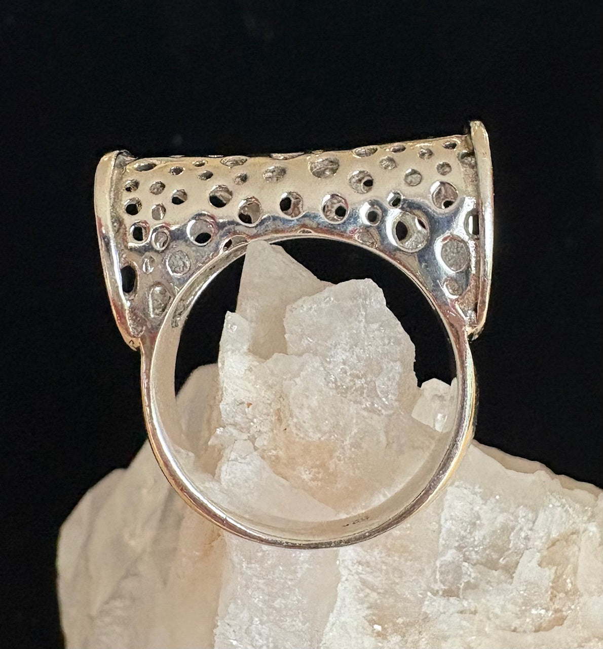 Silver ring with openwork design on a crystal background