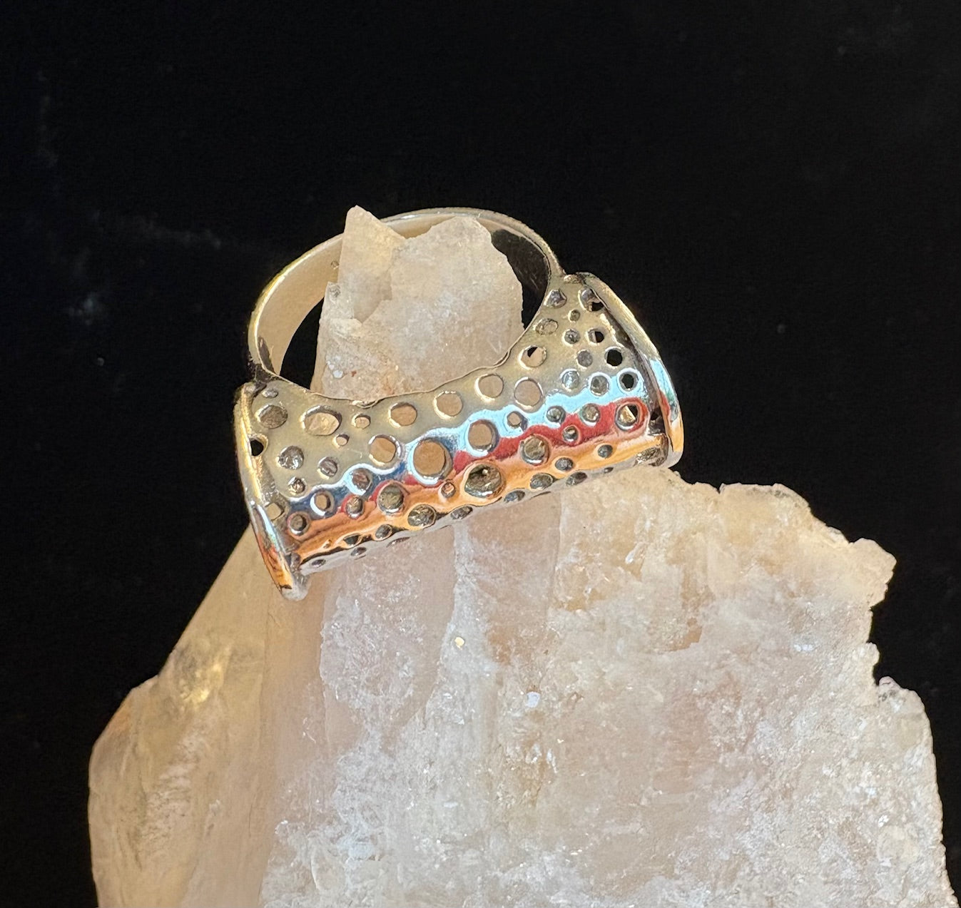 Sterling silver ring with cut out design on a crystal background