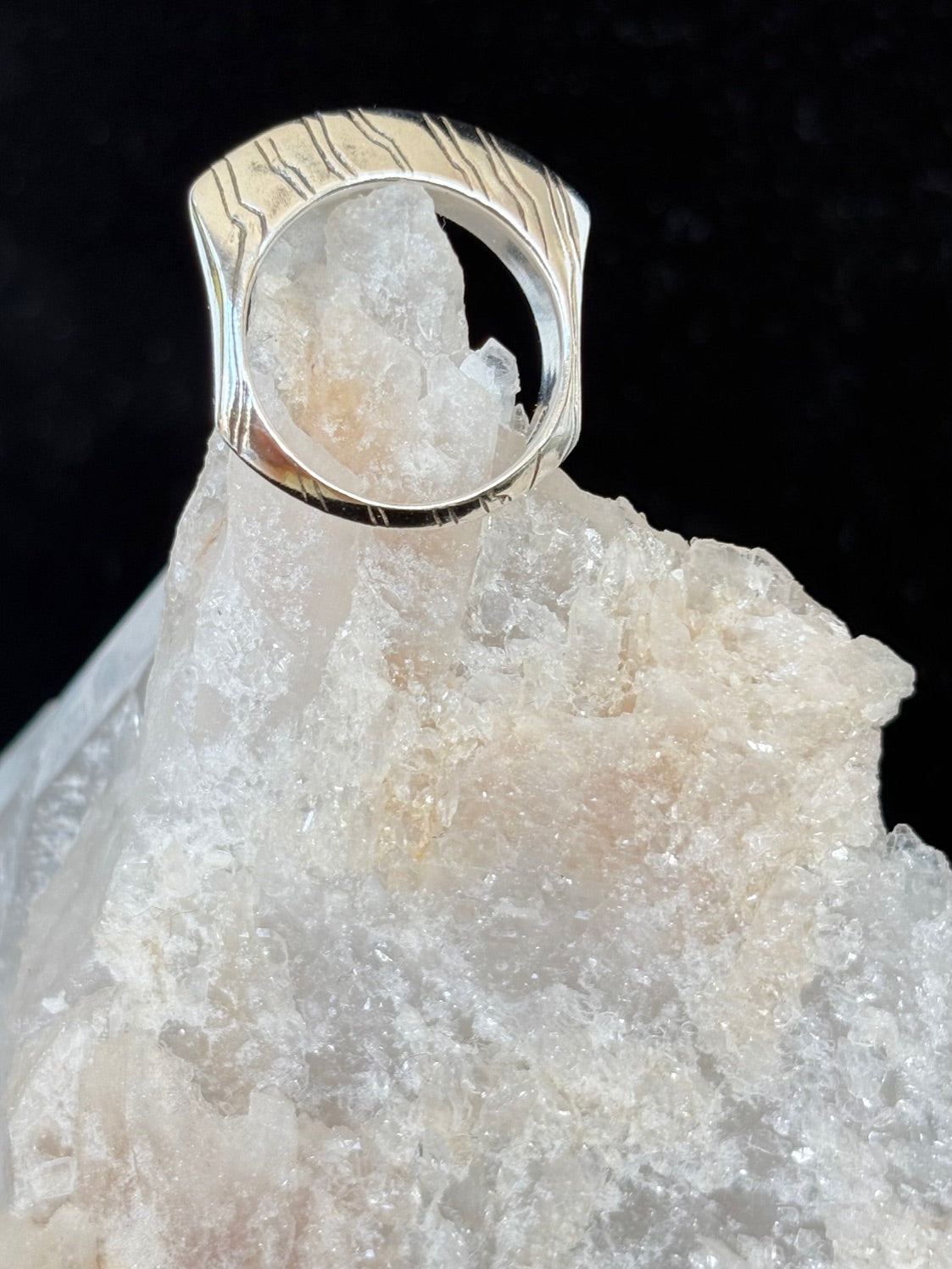 Silver ring with a unique design on a crystal background