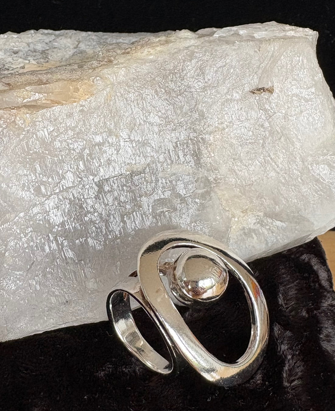 Silver ring with an open design on a rock background