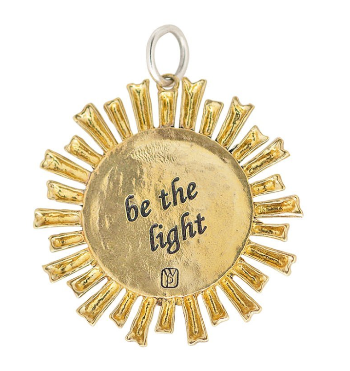 Sun shaped pendant with gold rays, sterling silver center with swarovski crystals. Made by Waxing Poetic.