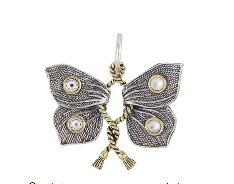 Butterfly-shaped pendant with intricate design on a white background