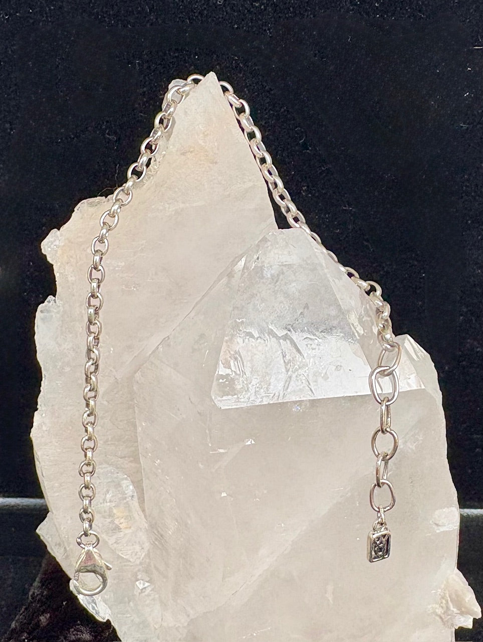 Waxing Poetic sterling silver bracelet on a crystal rock with a dark background