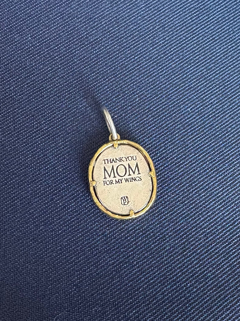 Waxing Poetic pendant with 'Thank you Mom for my wings' text on a blue fabric background
