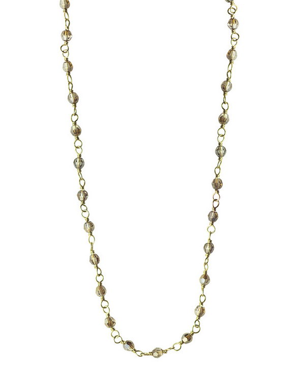 Gold chain necklace with small beads on a white background