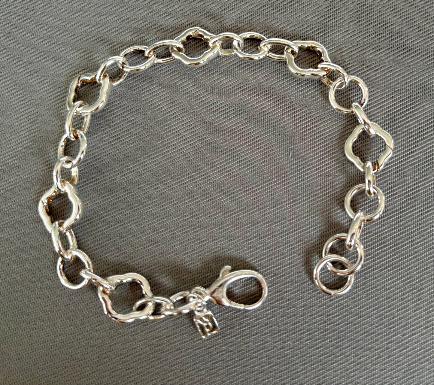 Sterling Silver chain charm bracelet on a gray background