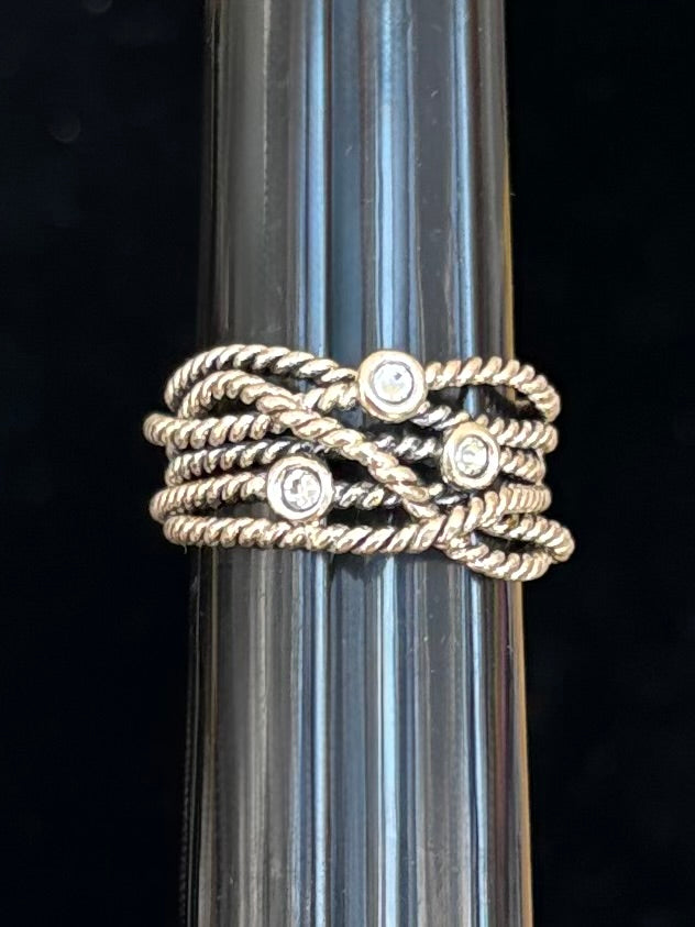 Silver ring with swarovski crystal accents on a clear glass rod against a black background