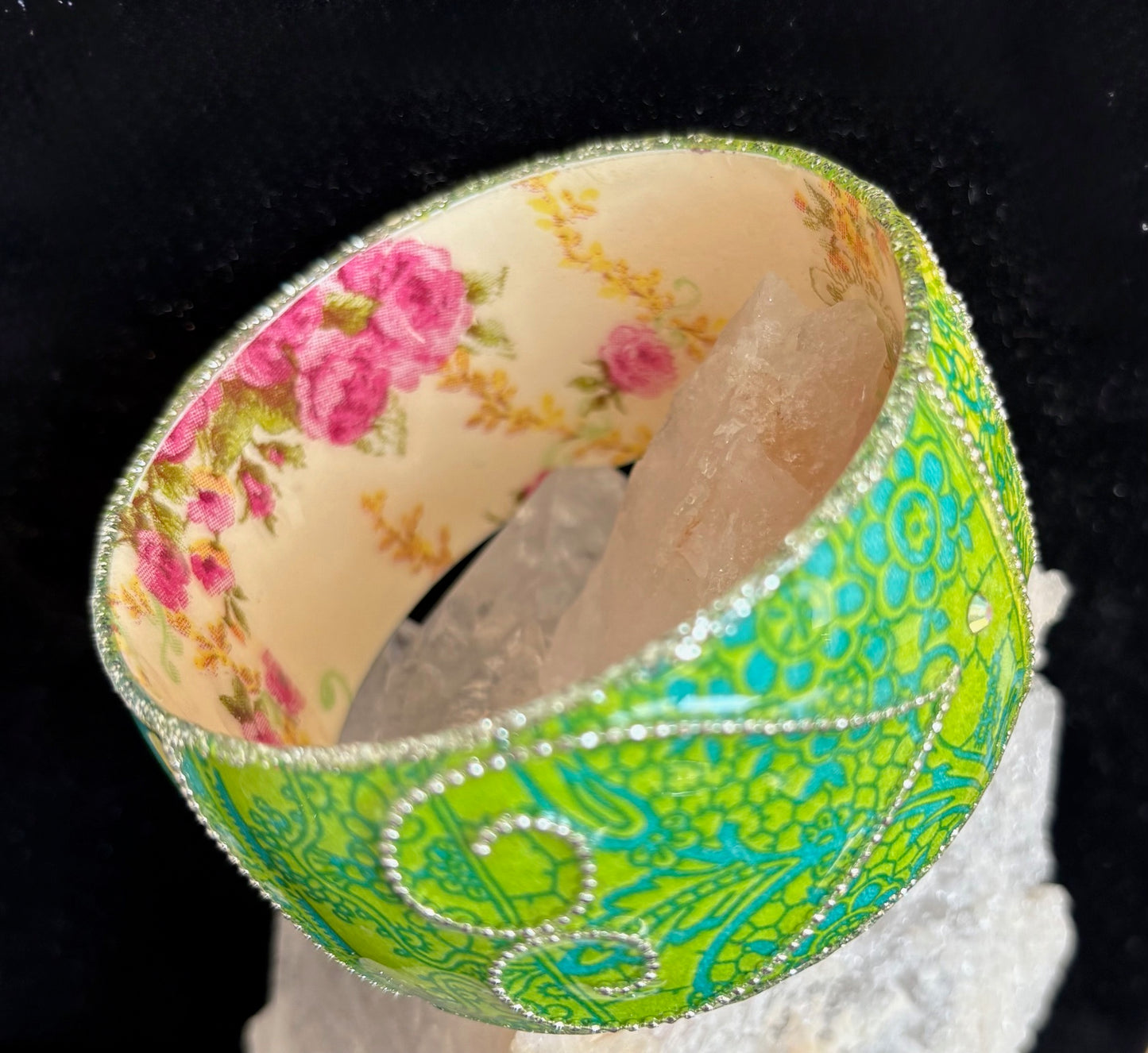 Floral and green patterned bangle on a black background