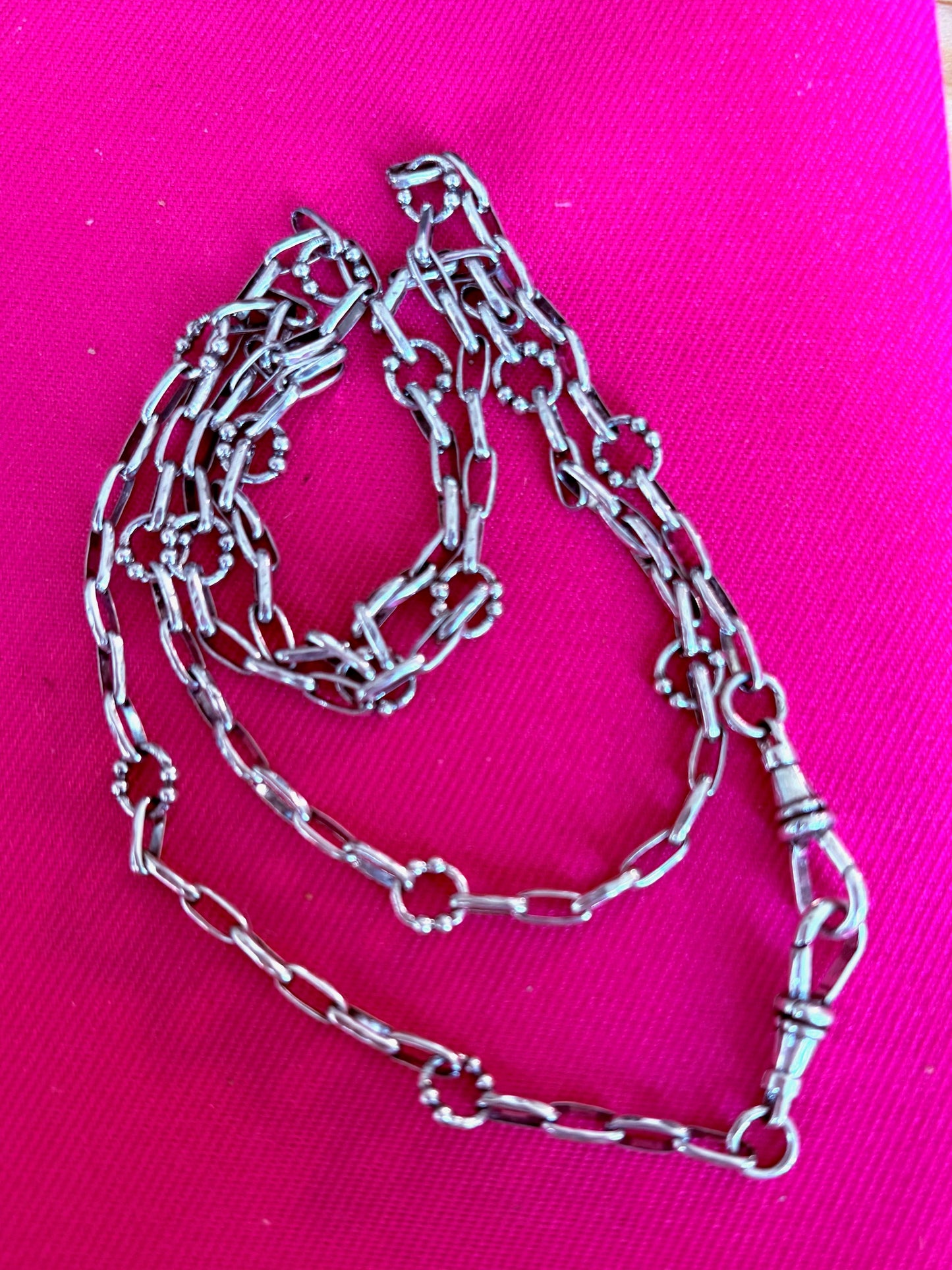 Waxing Poetic sterling silver chain on a pink background
