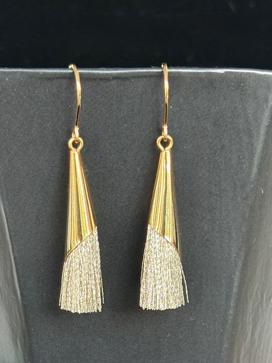 Gold tassel earrings on a black background