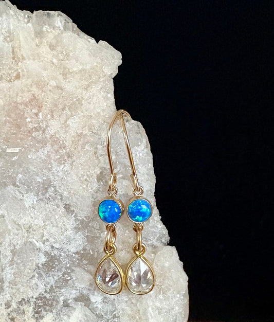 Jolie Esprit gold earrings with opal gemstones and diamond cubic zirconia teardrop stones on a crystal background