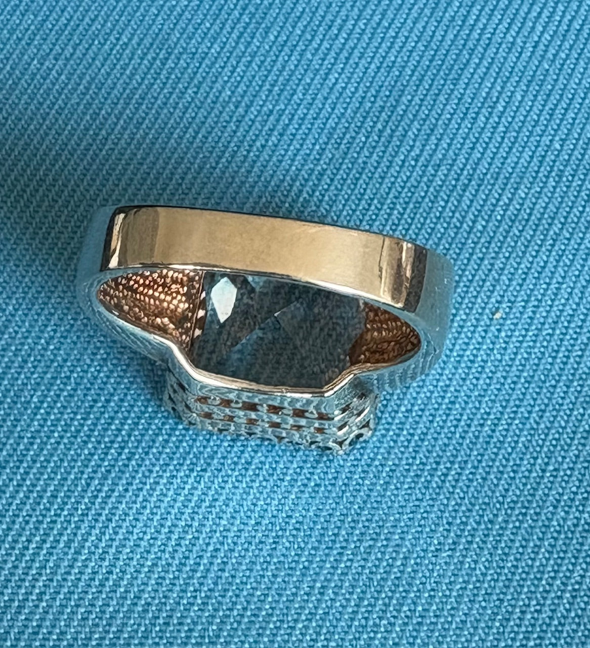 Back of silver ring  on a blue fabric background