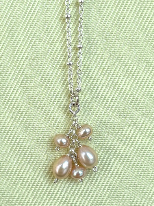 Necklace with pearls on a light green background