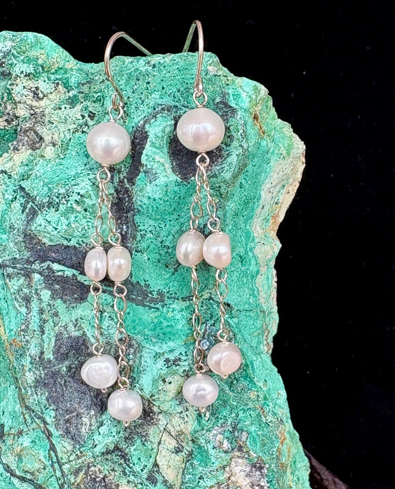 Jolie Esprit pearl earrings on a green stone background