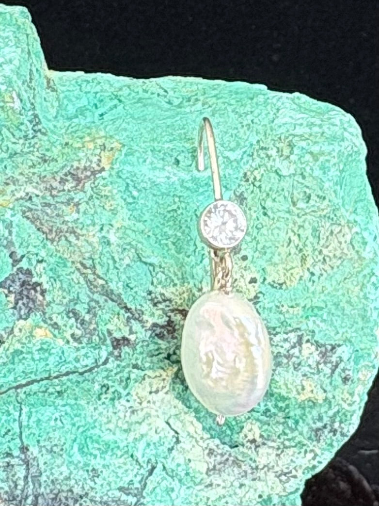 Pearl earring with a diamond CZ on a green stone background