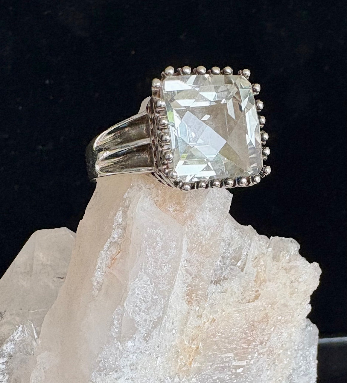 Jolie Esprit sterling silver ring with a large pale green gemstone on a crystal background