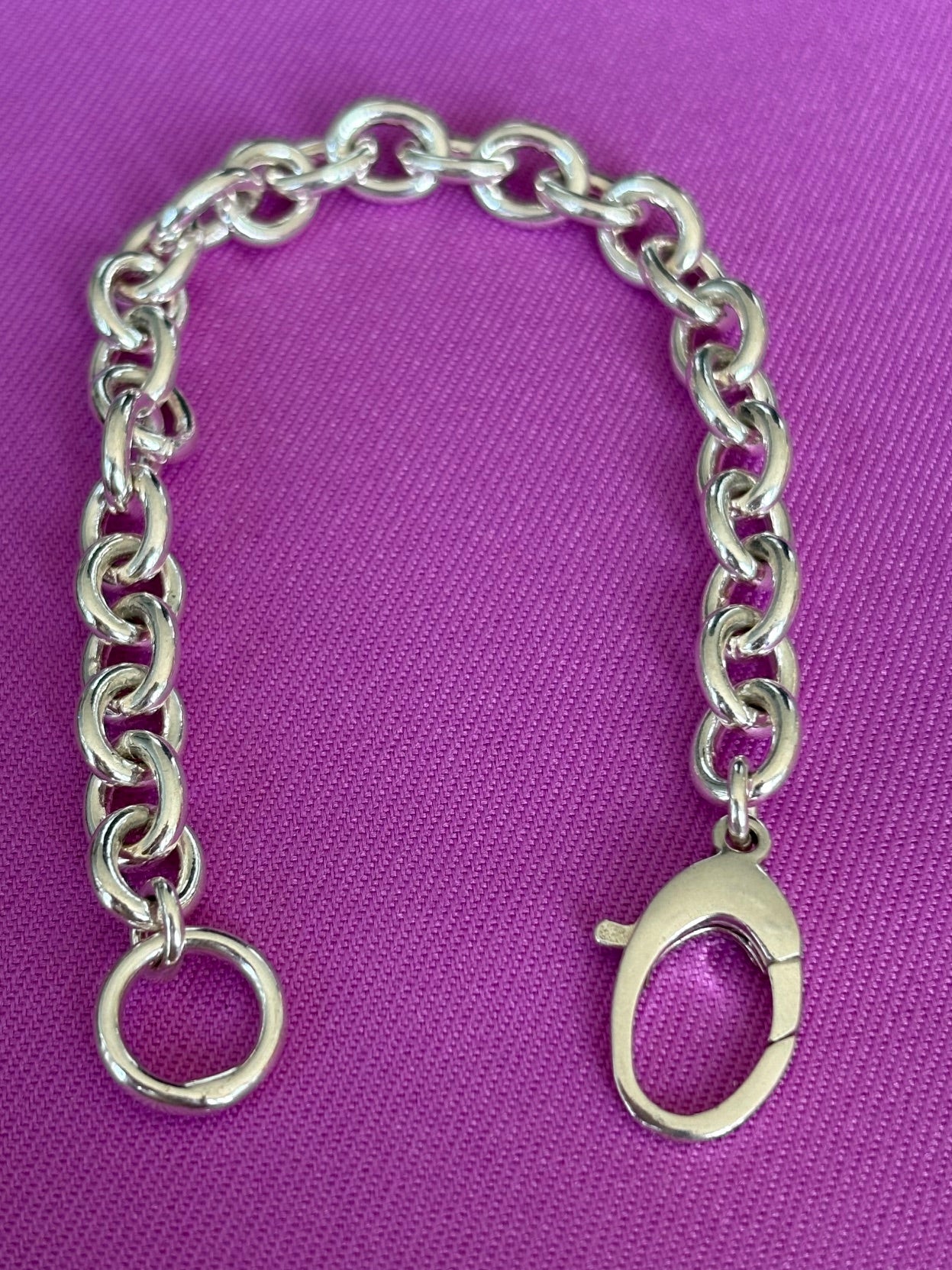 Stelring silver chain bracelet on a purple background